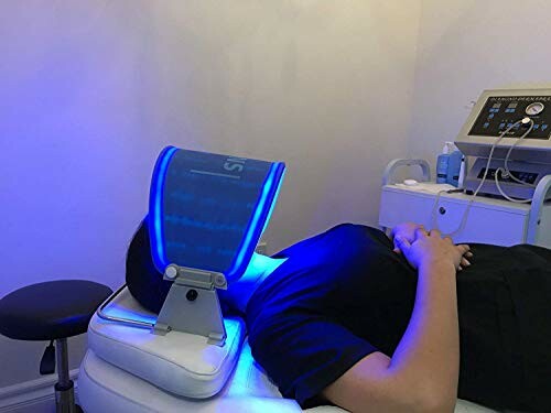 Person undergoing blue light therapy session in clinic.