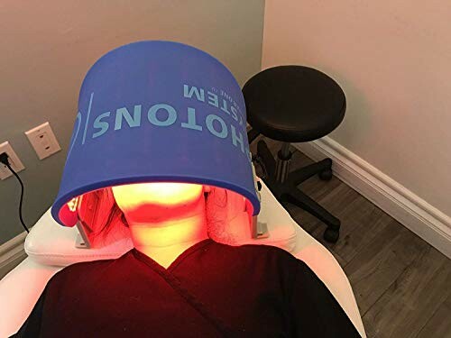 Person receiving LED light therapy with a blue hood device.
