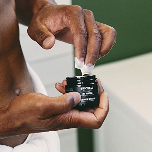 Man applying face cream from a jar