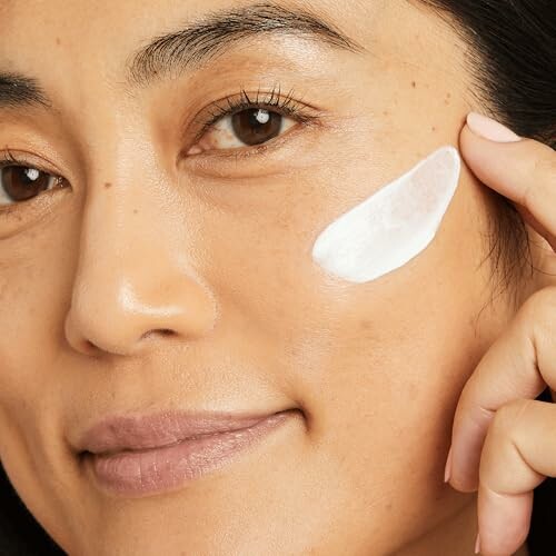 Woman applying No7 Lift & Luminate Day Cream to her cheek.